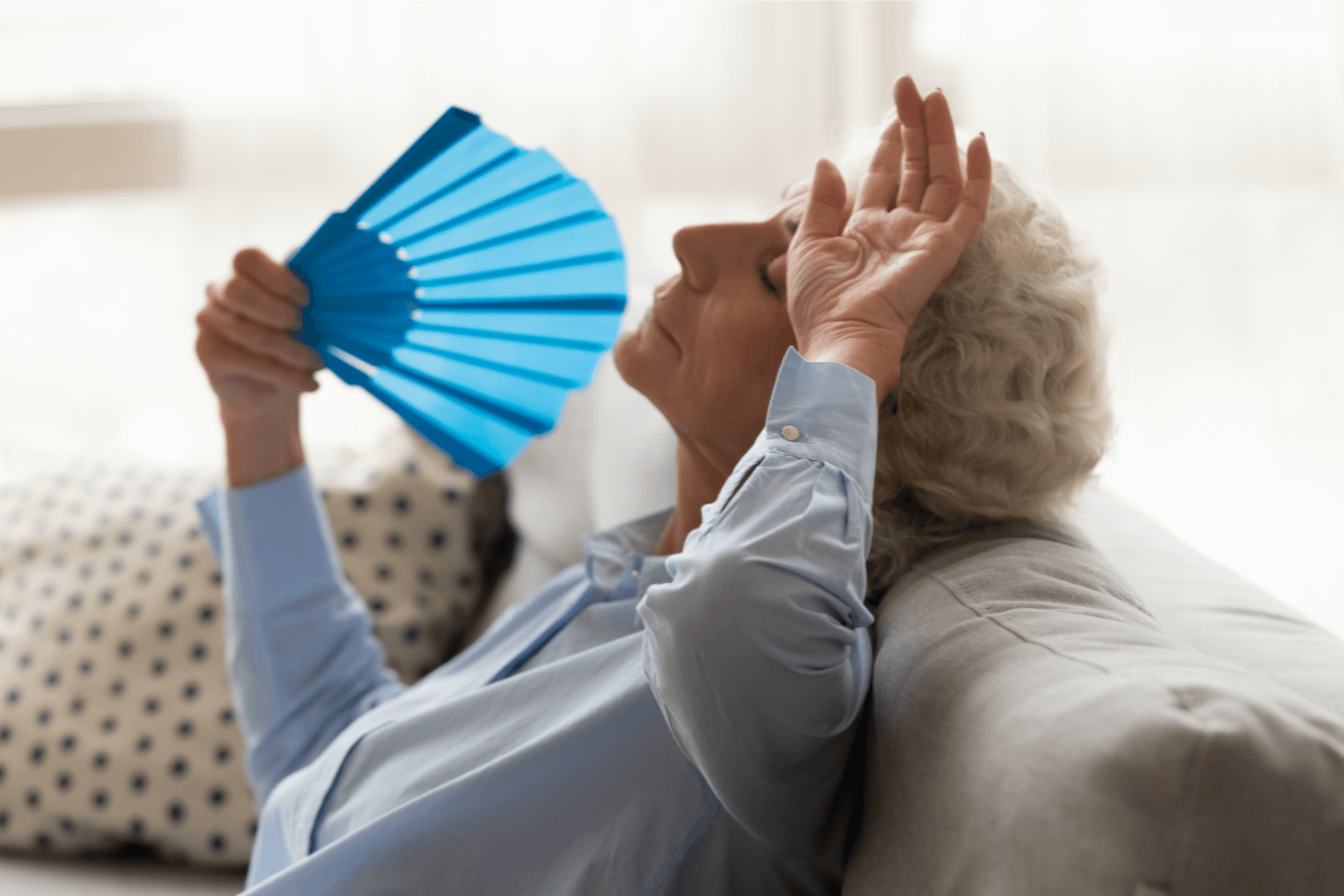Femme âgée pendant une canicule. Femme âgée qui se rafraîchi avec un éventail.
