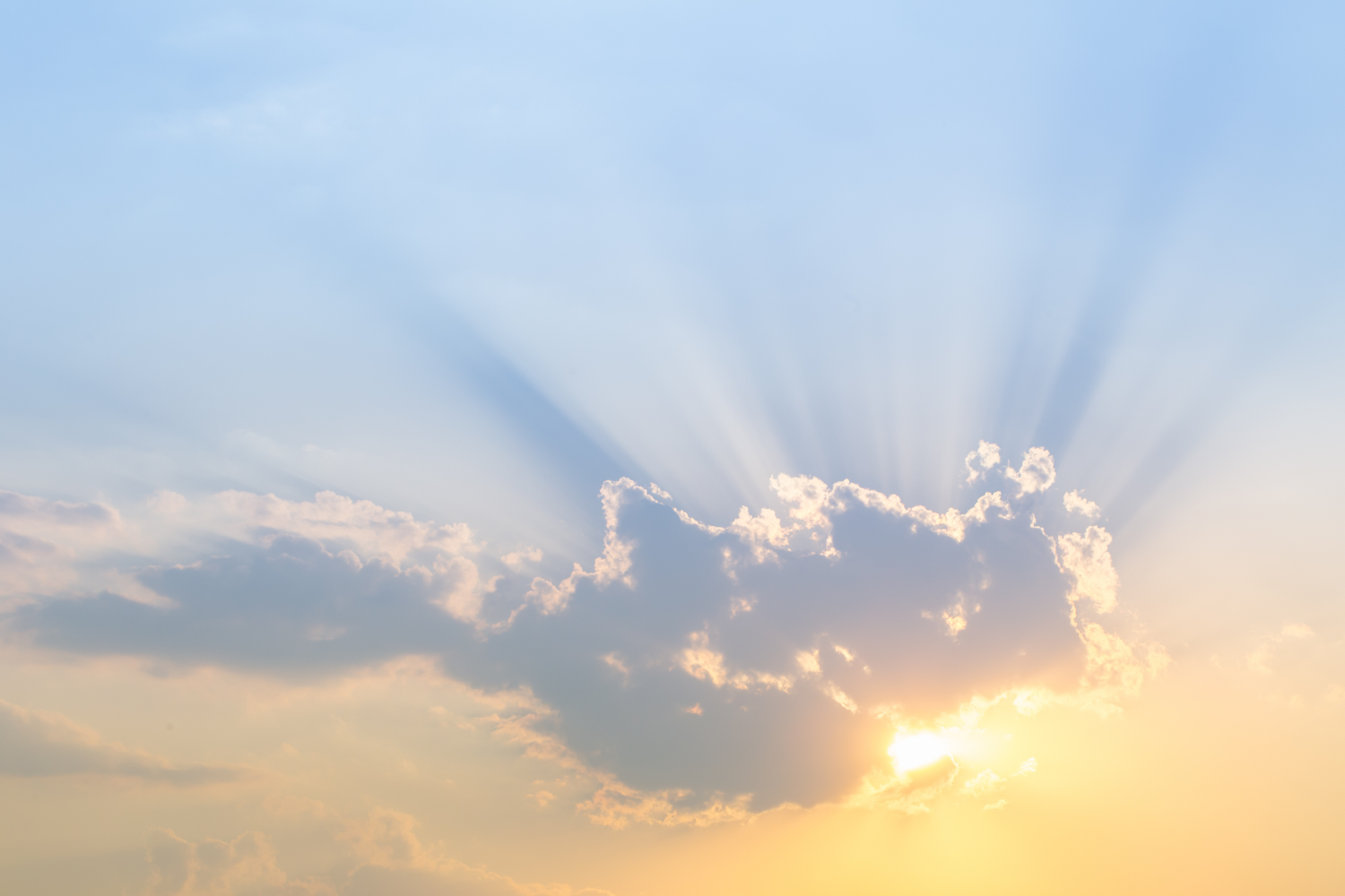 Soleil derrière un nuage sur un ciel bleu pastel.
